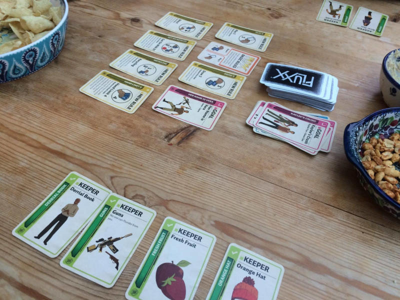 cards from the Firefly Fluxx game on a wooden table and two bowls of snacks