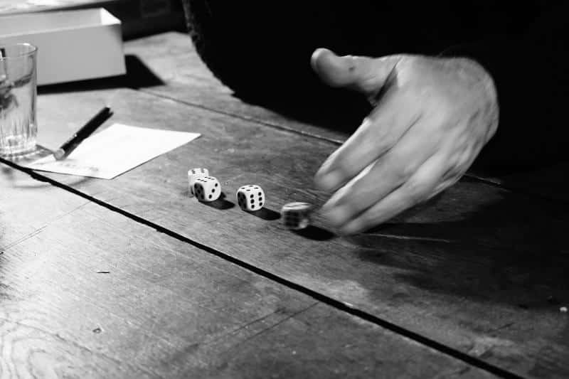 hand rolling dice (Photo by hidde schalm on Unsplash)