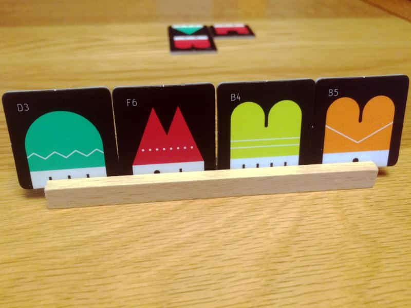 four tiles from Town 66 on their wooden rack in the foreground and three tiles on the table in the background