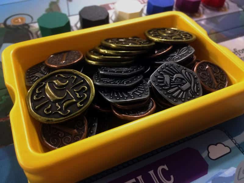 a yellow, plastic tray full of metal doubloons