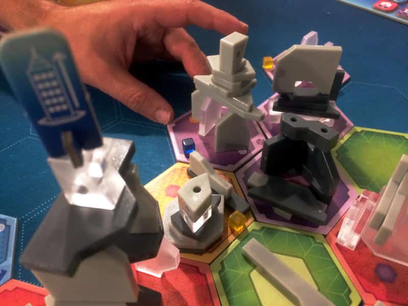 someone trying to move a hex tile with a MegaCity skyscraper to the middle of the table
