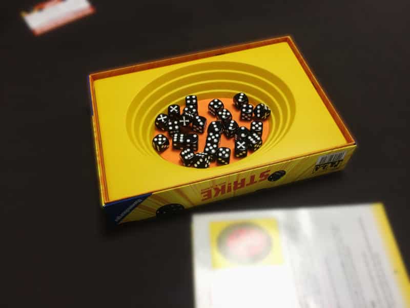 the game box with the plastic amphitheatre and a large number of black dice