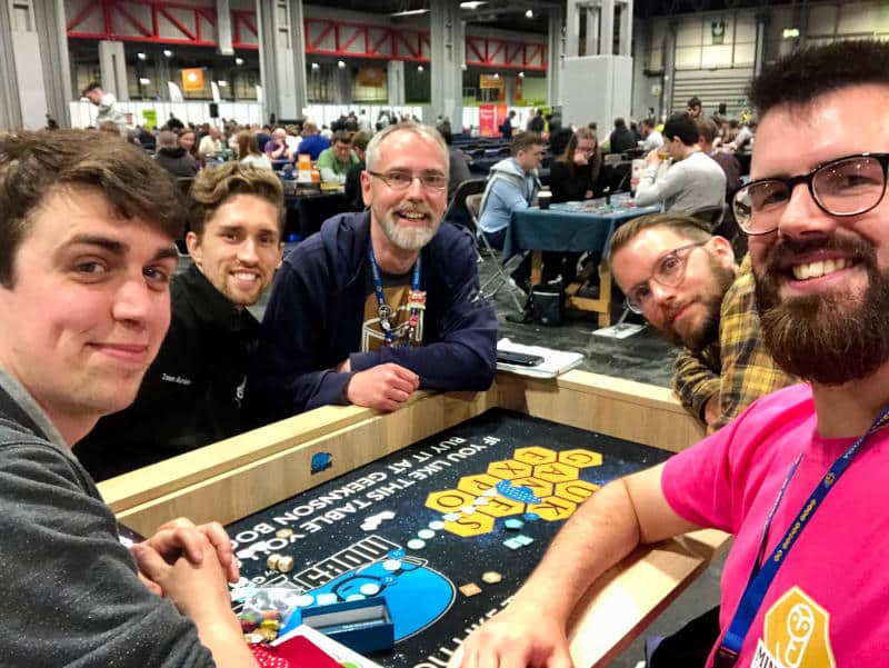 a selfie of four men in UK Games Expo's open gaming area (photo courtesy of Scott Lowe-James)