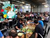people playing board games at the many open play tables at Berlin Brettspiel Con 2023 (logo courtesy of Berlin Brettspiel Con)