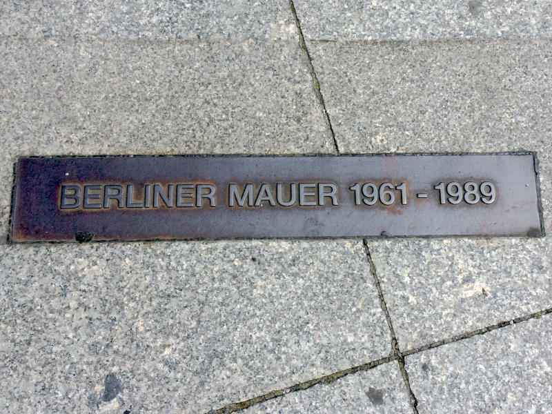 a plaque set into the ground marking where the Berlin Wall had been - the plaque reads: Berliner Mauer 1961 - 1989