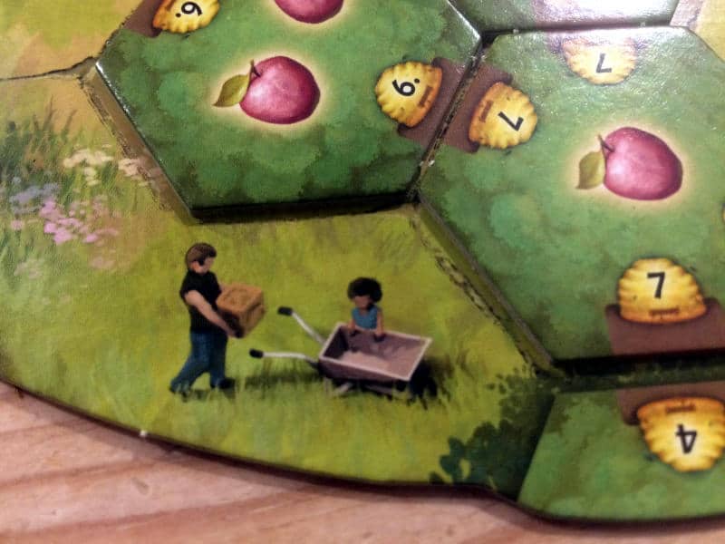 a beautiful illustration on your player board sowing a man carrying a box towards a wheelbarrow