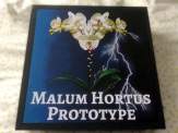 the box of the Malum: Hortus prototype box show an orchid half of which has eyes, tongues and sharp, pointy teeth
