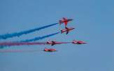 the Red Arrow RAF show planes performing with red, white and blue smoke trails (Photo by Ray Harrington on Unsplash)