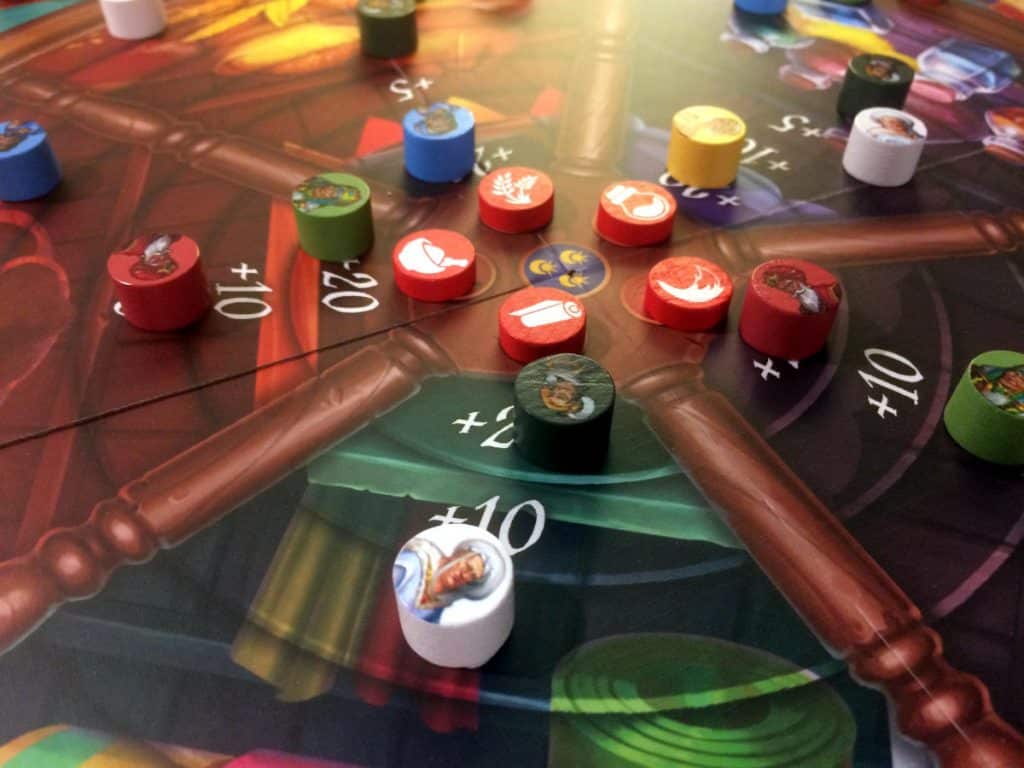 a close-up of the centre of the game board with the five goods tracks and different wooden player and goods tokens on it