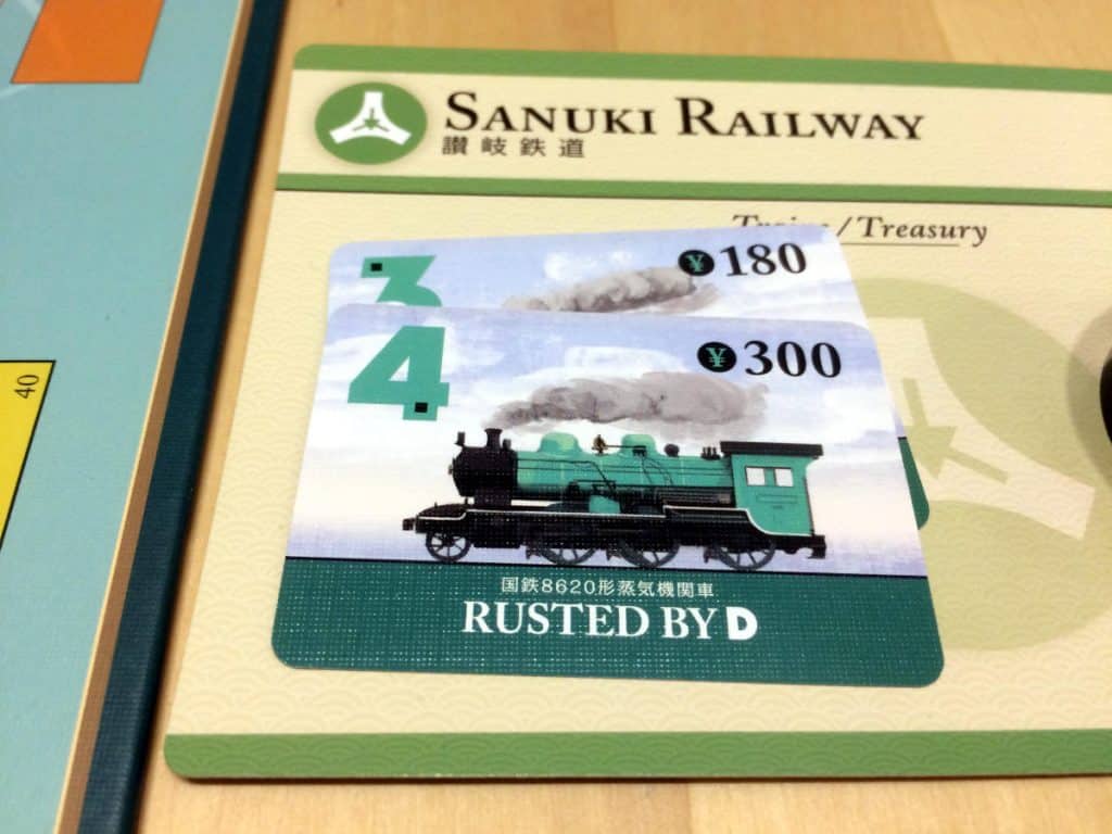 a close-up of Sanuki Railway's company tableau with a 3 and a 4 train card on it