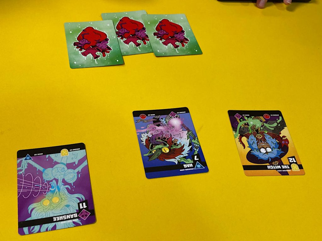 three life cards and three creature cards on a yellow table