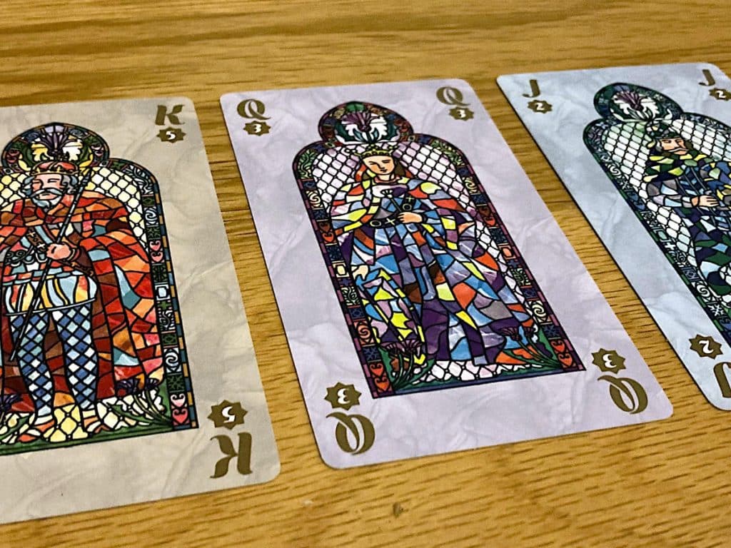 king, queen and jack cards lined up side-by-side on a table