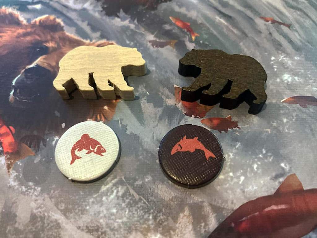 one Cinnamon and on Sandy bear meeple and one of each salmon tokens