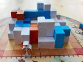 blue, orange and white building blocks creating a mini Pueblo with the eagle-shaped chieftain token in front, all on top of the rotating platform
