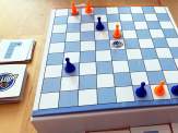 the checker board, four orange pawns, four blue pawns and some movement cards from Booted!