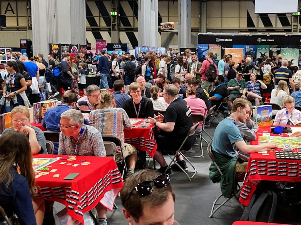 lots of people playing games at tables with red table cloths