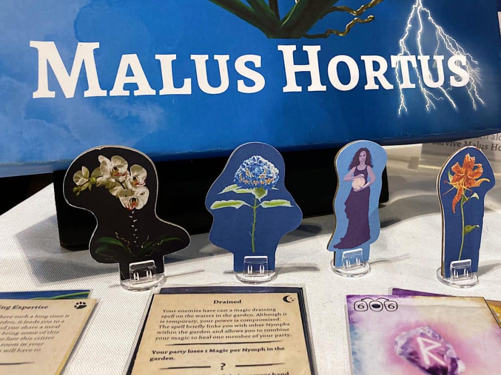 a close-up of some of the standees and cards from Malus Hortus