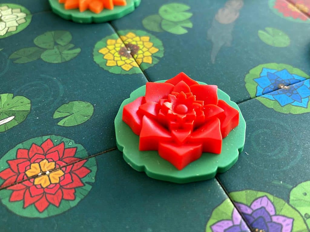 a close-up of the red bloom token from the Deluxe edition of A Gentle Rain
