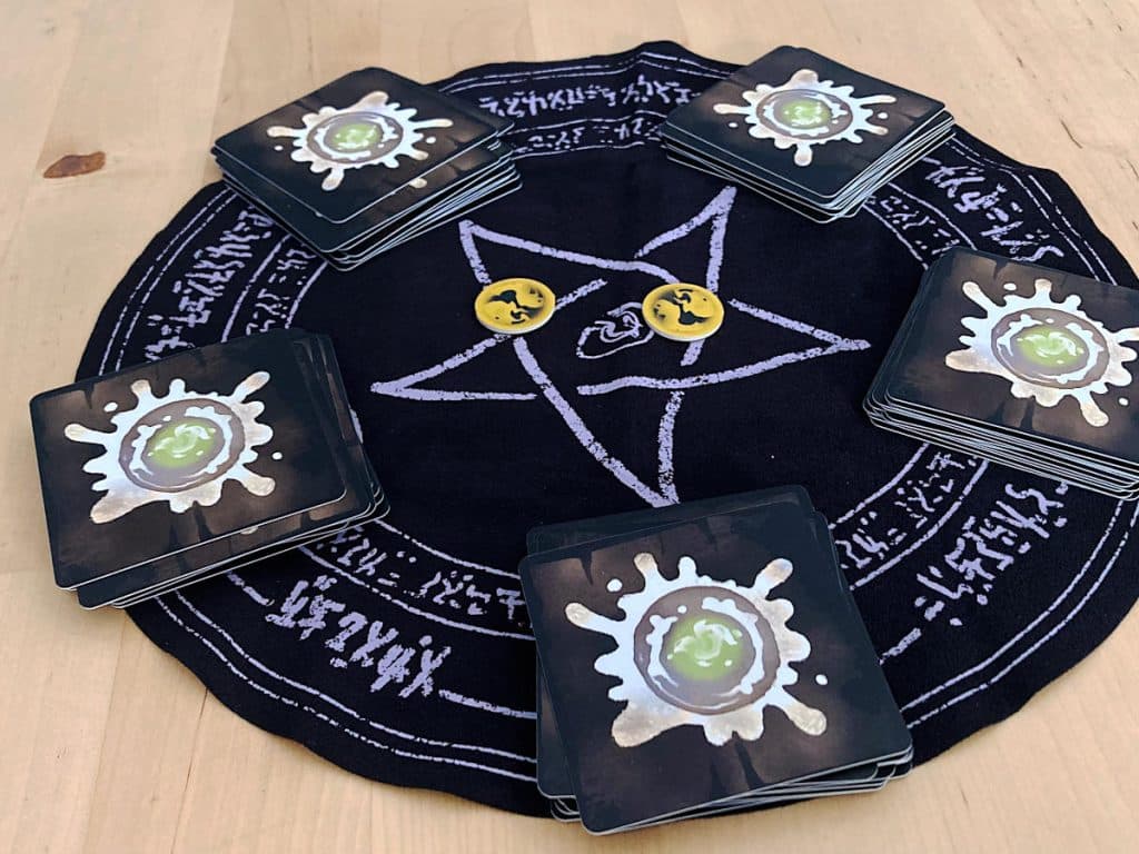 the black summoning circle cloth with the pentagon star drawn on it and the five candle decks