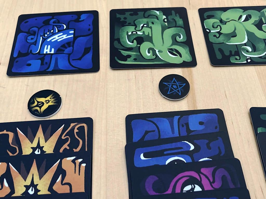 some of the cards and tokens from Club of Cthulhu on the table