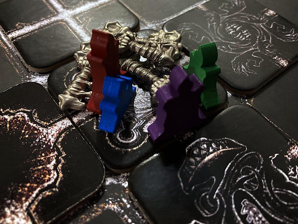 four candle meeples and four silver skeleton keys on a gate tile