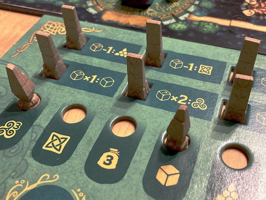 a player board with a number of plastic standing and rune stone tokens