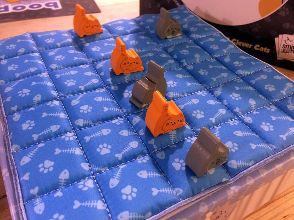 a number of kittens lined up on the quilt game board